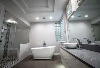 Luxury bathroom remodel in Sierra Madre with freestanding tub and glass block windows